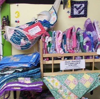 Cradle Size Baby Quilts Display at Retail Shop of Long Meadow Farms Quilts